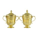 A good pair of George II embossed silver gilt two handled pedestal cups and covers, by Benjamin