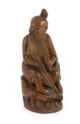 A Chinese bamboo figure of a seated fisherman, 19th century, Holding a rod in his right hand and a