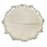 A George V silver salver, by Adie Brothers, of shaped circular form, with shell border, on three