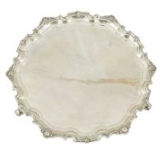 A George V silver salver, by Adie Brothers, of shaped circular form, with shell border, on three