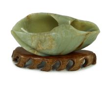 A Chinese green and russet jade ‘lotus leaf’ brushwasher, 17th/18th century, carved as a curled
