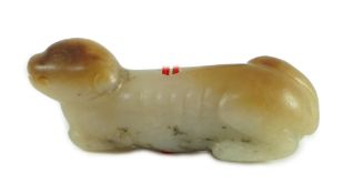 A Chinese pale grey and russet jade figure of a hound, probably Song dynasty, the hound recumbent,