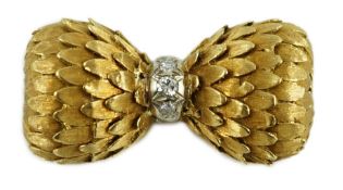 A stylish 1960's textured 18ct gold and three stone diamond set bow brooch, 32mm, gross weight 9.7