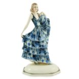 A Goldscheider Art Deco pottery figure of a dancer, modelled by Dakon, wearing a blue floral