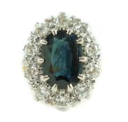 An 18ct gold, sapphire and diamond set oval cluster dress ring, the sapphire of a dark green