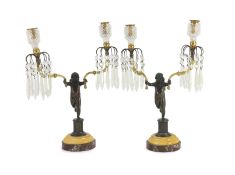 A pair of early 19th century bronze and ormolu figural candelabra, each modelled as a cherub holding