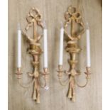 A pair of Louis XVI style carved giltwood wall lights, with ribbon crests and winged eagle stems,