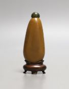 A Chinese brown glass ‘pebble’ snuff bottle in imitation of stone, wood stand Bone spatula