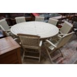 A circular painted teak garden table, diameter 180cm, height 72cm and eight matching folding