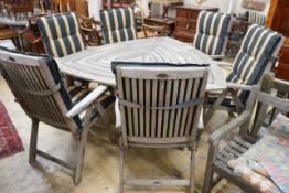 A Hartman weathered teak triangular garden table, width 170cm, height 76cm, six folding armchairs