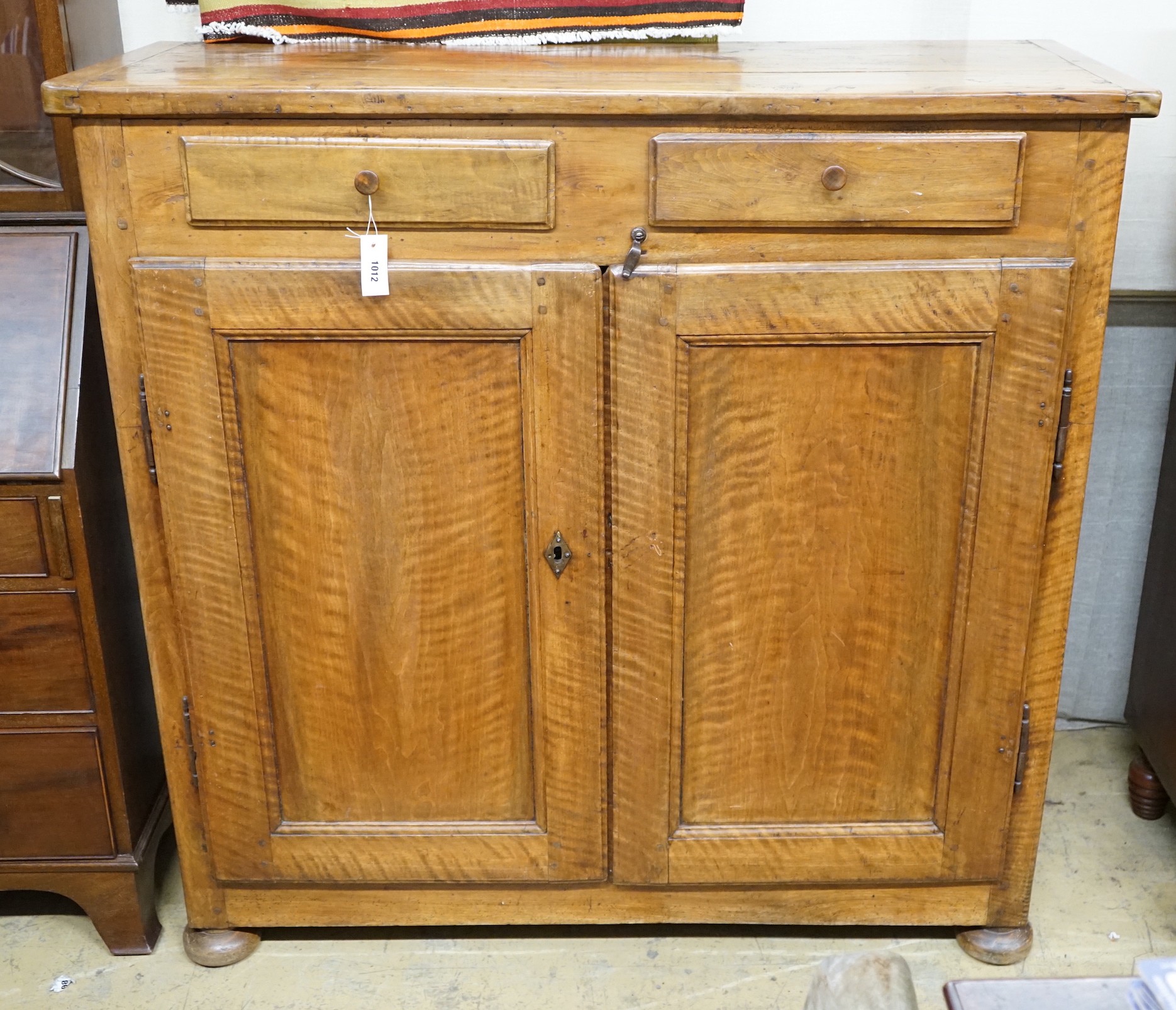 A late18th century continental fruitwood two drawer side cabinet, width 128cm, depth 47cm, height