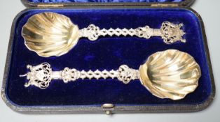 A cased pair of ornate late Victorian silver serving spoons, with entwined stems and terminals