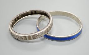 A 1920's silver and blue enamel bangle and an engraved white metal bangle.