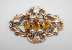 A Victorian yellow metal and three stone oval cut citrine set brooch, 54mm.