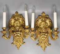 A pair of gilt carved wooden two branch wall sconces,42 cms high.