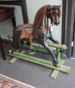 An early 20th century painted carved wood rocking horse on pine safety frame, length 132cm, height