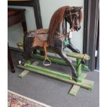 An early 20th century painted carved wood rocking horse on pine safety frame, length 132cm, height