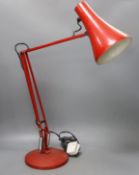 A red anglepoise desk lamp