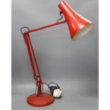 A red anglepoise desk lamp