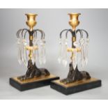 A pair of lustre drop 'sphinx' candlesticks - 23cm tall