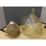 A large clear glass carboy and unusual wire-mounted glass carboy,largest 28cms high.