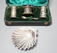 A late Victorian silver butter shell, London, 1892, 11.5cm and a cased George V silver three piece