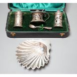 A late Victorian silver butter shell, London, 1892, 11.5cm and a cased George V silver three piece