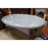 A Bramblecrest oval all weather rattan glass topped garden table, length 220cm, depth 144cm,