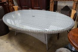 A Bramblecrest oval all weather rattan glass topped garden table, length 220cm, depth 144cm,