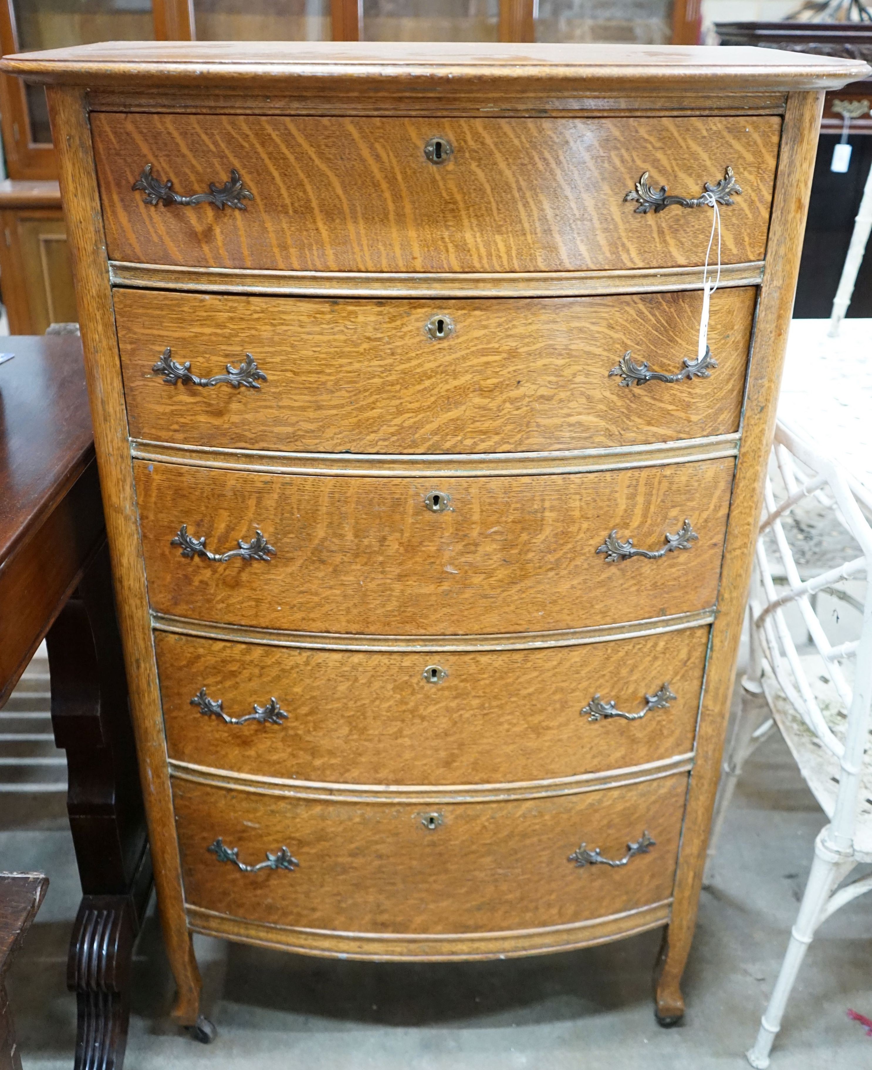 An early 20th century oak bow front tall chest, width 76cm, depth 49cm, height 123cm