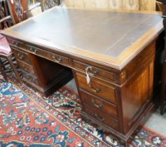 A reproduction Georgian style mahogany twin pedestal desk, fitted nine short drawers, on plinth