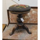 A Victorian mahogany adjustable revolving piano stool with tapestry seat