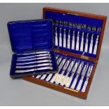 A cased set of silver handled pistol knives and a cased set of mother-of-pearl fruit knives and