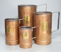 A graduated set of four copper and brass grain measures,tallest 39.5 cms high.