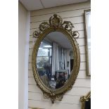 A Victorian giltwood and gesso oval wall mirror, width 61cm, height 110cm