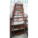 A late Victorian rosewood serpentine front six tier whatnot with mirror and barley twist support