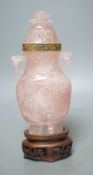 A late 19th/early 20th century Chinese carved rose quartz vase and cover, on a Hongmu stand,23.5