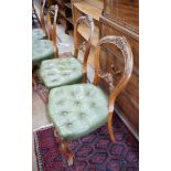 A set of six Victorian carved walnut and buttoned green leather spoon back dining chairs