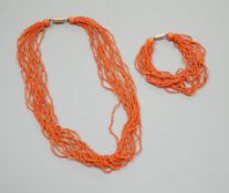 A multi strand coral bead necklace, 39cm and matching bracelet, 15.5cm, both with yellow metal