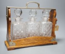 Early 20th century Betjemann's patent oak 3 bottle tantalus,32 cms high.