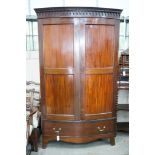 An early 20th century George III style mahogany bowfront wardrobe, with hanging space and one long