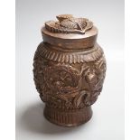 A Burmese carved wooden tobacco jar and cover - 17cm tall