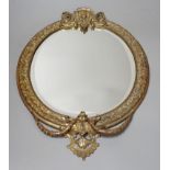 An early 20th century decorative gilt metal mirror, 41 cms high