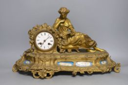A French gilt metal mantel clock with blue enamel floral decoration and mounted lady reading -