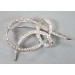 A white metal and diamond cluster set scroll brooch, 52mm, gross weight 14 grams.