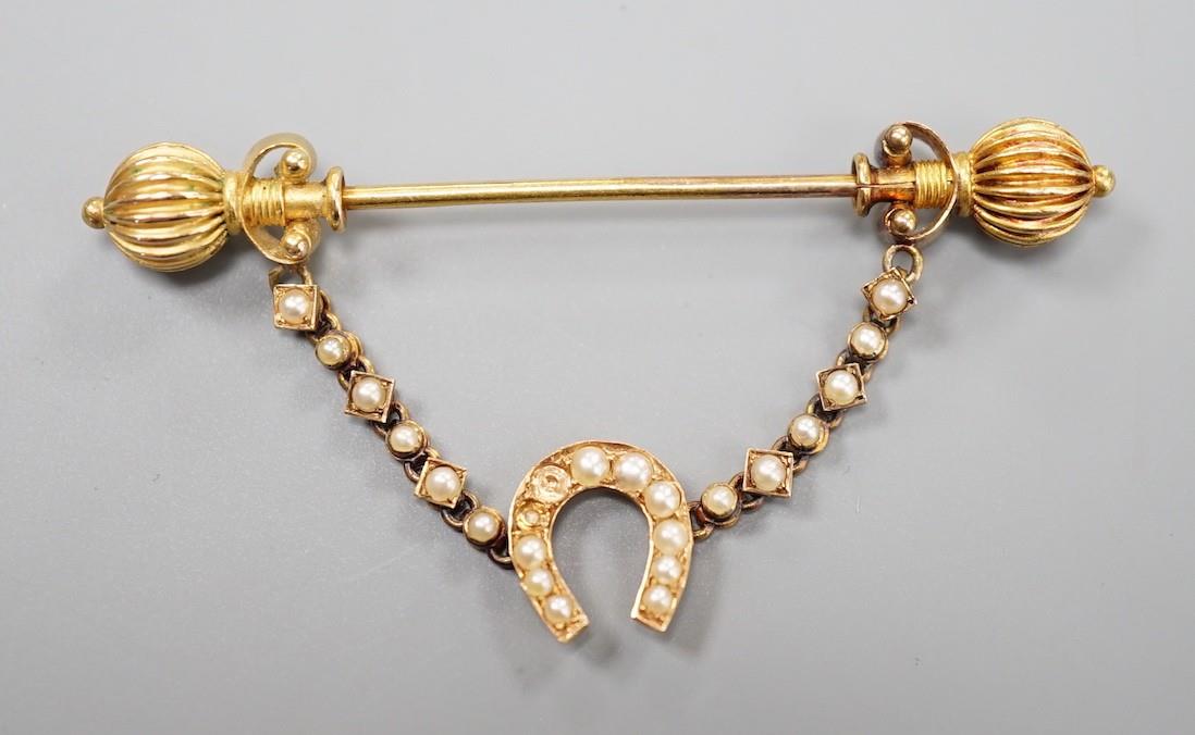 An early 20th century yellow metal and seed pearl horseshoe swag jabot pin, 59mm, gross weight 4.9