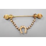 An early 20th century yellow metal and seed pearl horseshoe swag jabot pin, 59mm, gross weight 4.9