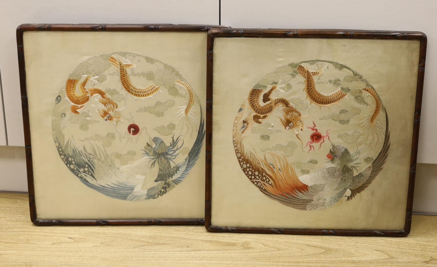 A pair of Chinese embroidered silk dragon and phoenix roundels, c1910, hougmu frames