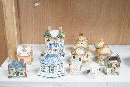 Twelve Staffordshire pottery money boxes, three with sponged decoration, modelled as cottages or
