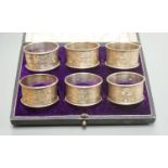 A cased set of six Edwardian engraved silver napkin rings, J & R Griffin, Chester, 1902.